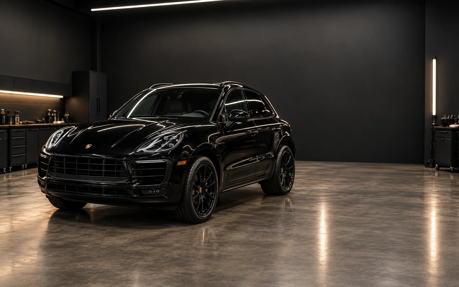 Black Porsche Macan inside a dark premium detailing studio